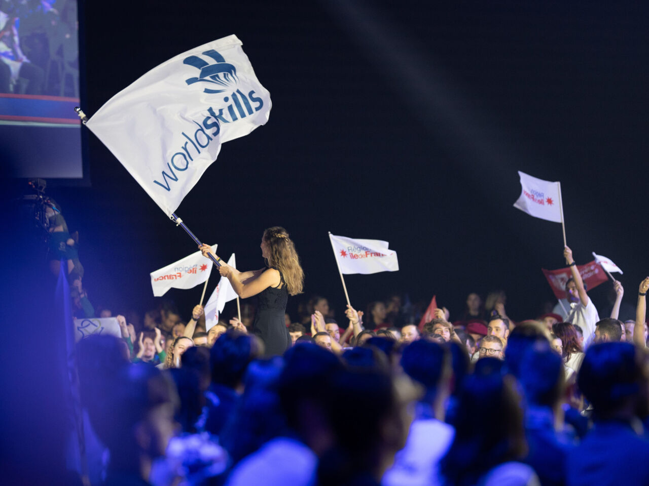 WorldSkills Champions Trust representative for Europe, Cloé Lemarechal, carries the WorldSkills flag across the stage during the Closing Ceremony.
