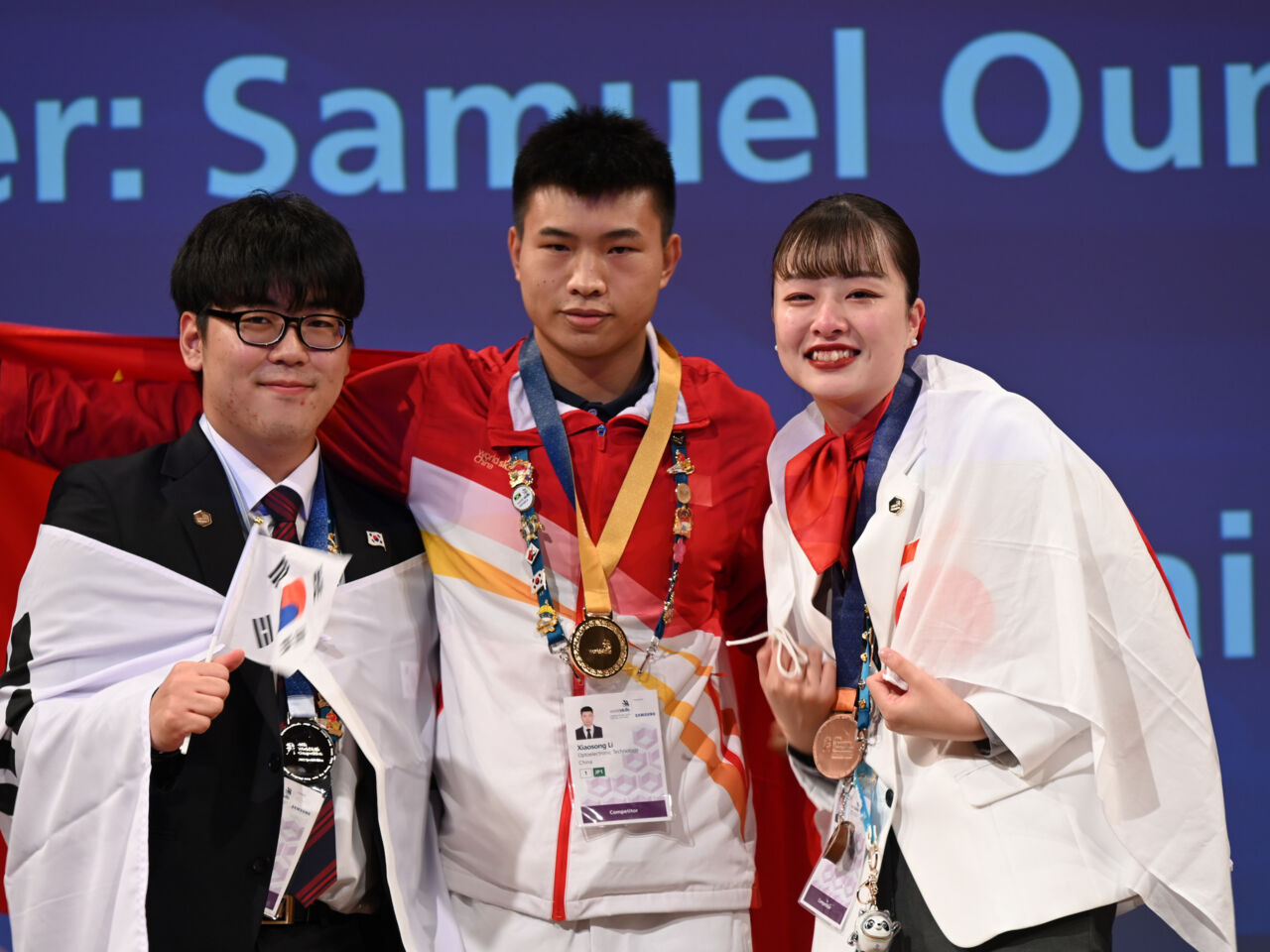 Nene Arai celebrates winning a bronze medal alongside fellow medal winners in Optoelectronic Technology at WorldSkills Competition 2022 Special Edition in Kyoto, Japan.